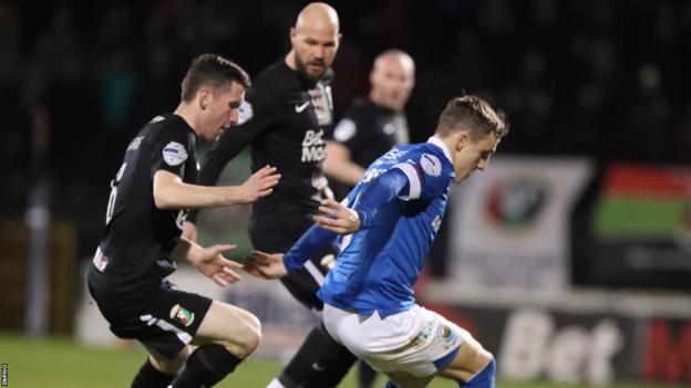 Glentoran's Bobby Burns and Hrvoje Plum in action against Joel Cooper of Linfield