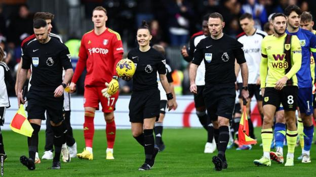 Referee Rebecca Welch walks out with the match ball with her fellow officials before Fulham v Burnley at Craven Cottage