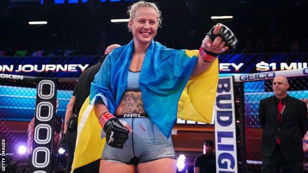 Olena Kolesnyk carries the Ukrainian flag and smiles