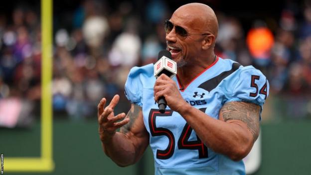 Dwayne Johnson speaking on the field before the opening game of the 2023 XFL season
