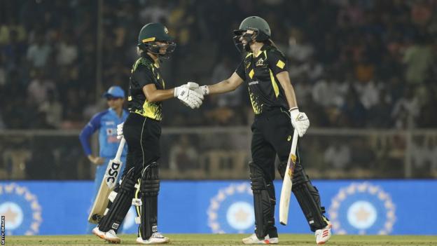 Ash Gardner (L) and Ellyse Perry (R) shake hands as they beat for Australia against India