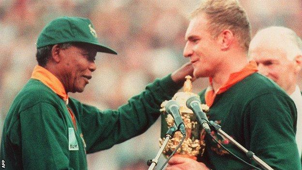 Nelson Mandela, then president of South Africa, presents the World Cup trophy to Francois Pienaar