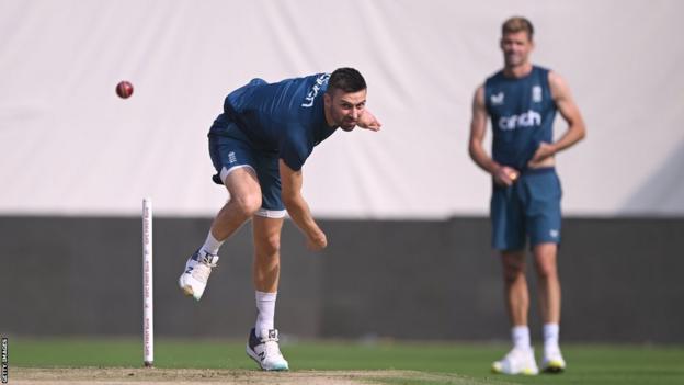 England bowler Mark Wood bowls in the nets, watched by James Anderson, during tour of India