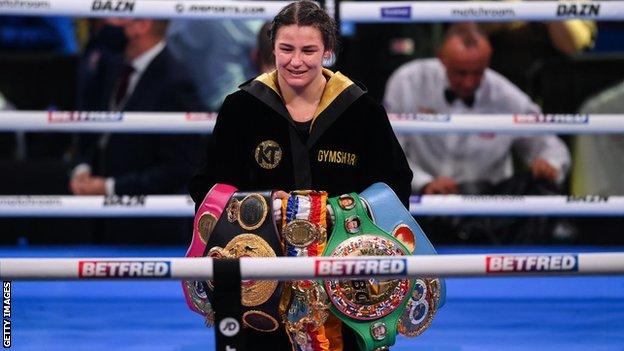 Katie Taylor smiles with all her belts