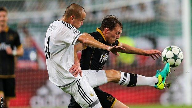 Adam Hlousek and David McMillan challenge for the ball in Warsaw