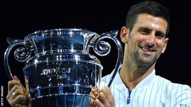 Novak Djokovic collects the trophy for finishing 2020 as the world's top men's player