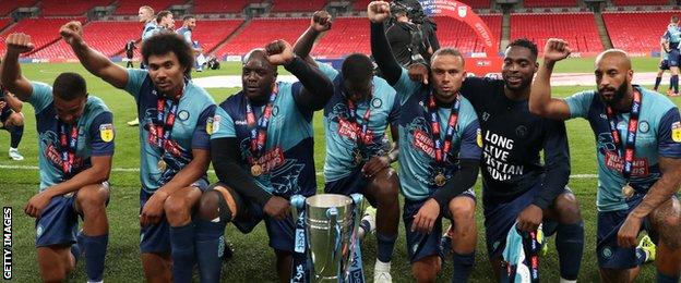Wycombe players take a knee after winning the play-off final