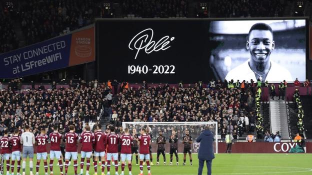 West Ham players looking up at a tribute to Pele on the big screen