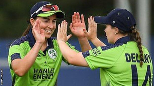 Wicket-taker Arlene Kelly is congratulated by captain Laura Delany