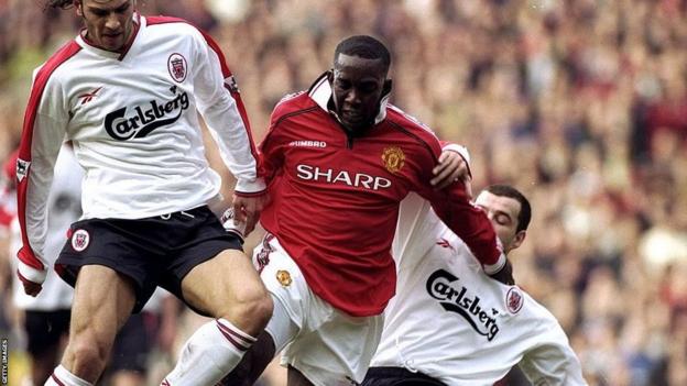 Dwight Yorke battles for possession with Liverpool players in 1999