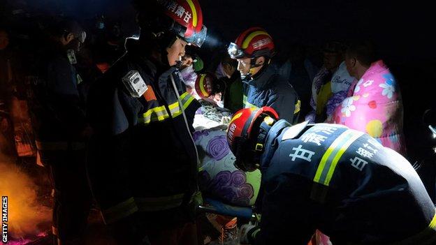 Rescuers search and assist survivors