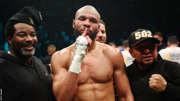 Chris Eubank Jr puts his finger to his lips next to trainer Brian 'Bomac' McIntyre