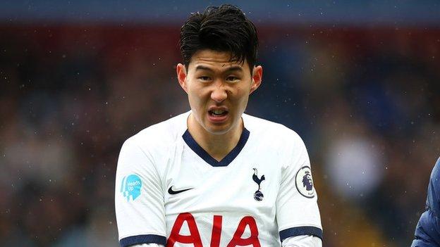 Tottenham forward Son Heung-min holding his arm in pain