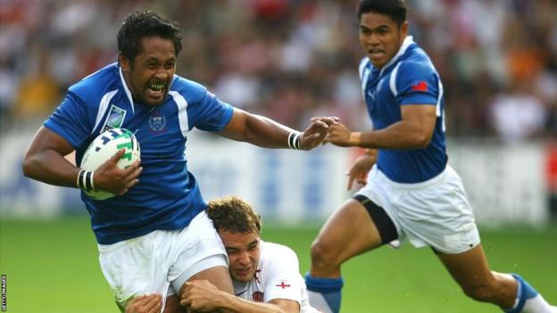 Current Samoa coach Seilala Mapusua is tackled by Olly Barkley in the teams' 2007 Rugby World Cup meeting