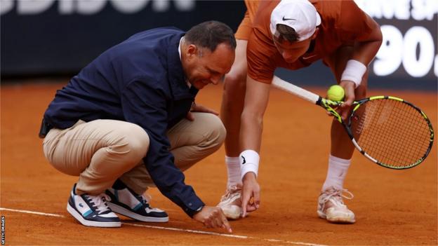 Umpire Mohamed Lahyani and Holger Rune discuss a ball mark at the Italian Open