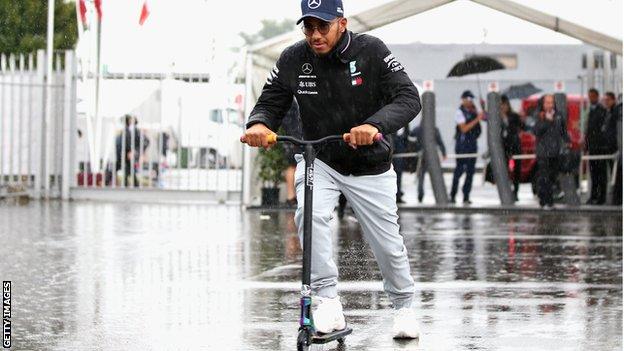 Lewis Hamilton rides his scooter in the Monza paddock