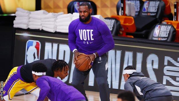 LeBron James warming up wearing a T-shirt with the word 'vote' on the front