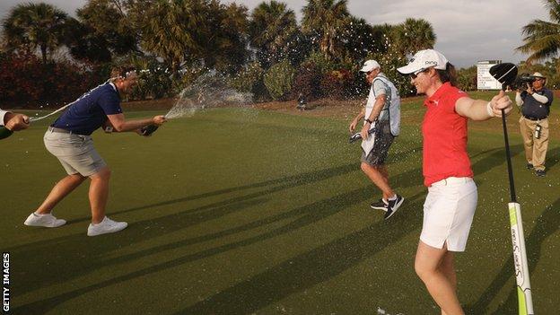 Maguire gets soaked in champagne on the 18th green