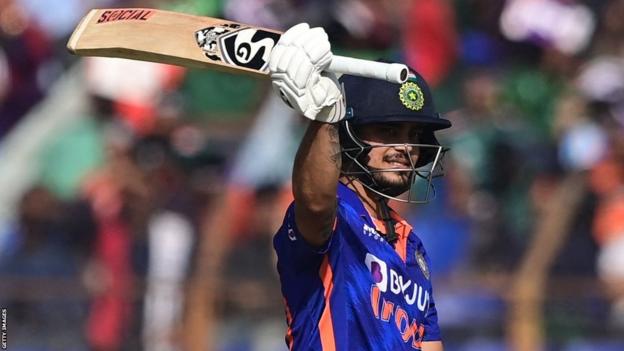 India batter Ishan Kishan raises his bat after reaching his century against Bangladesh