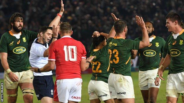 Dan Biggar remonstrates with the referee as South Africa players celebrate the award of a penalty