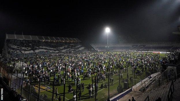 Fans flooded the Gimnasia field as they tried to escape the clashes off the ground