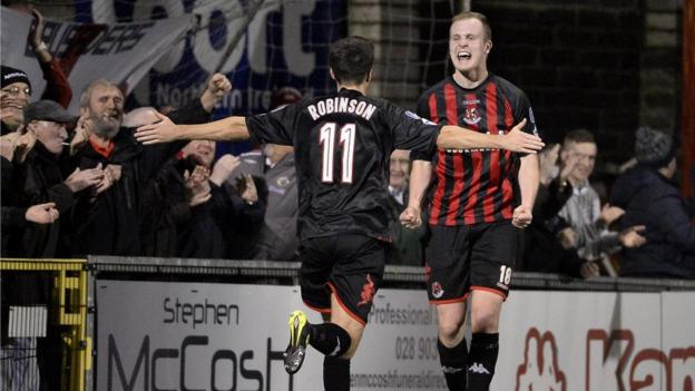 Josh Robinson prepares to congratulate Jordan Owens after the striker makes it 3-1 to Crusaders against Coleraine