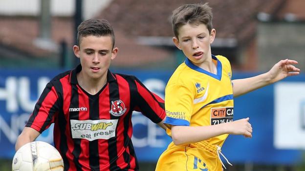 Ross Ferguson of Crusaders in action against Trojans player Aiden Rakin in the Under-15 section of the Foyle Cup