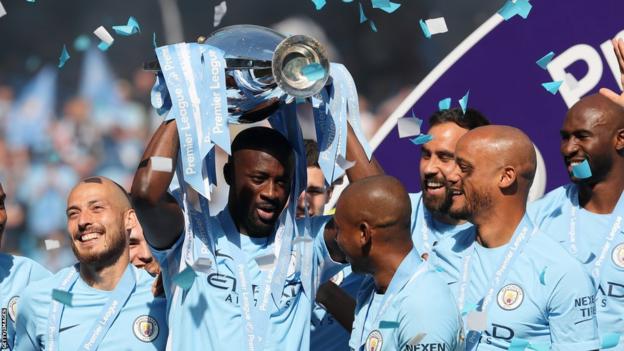 Yaya Toure holds the Premier League trophy aloft