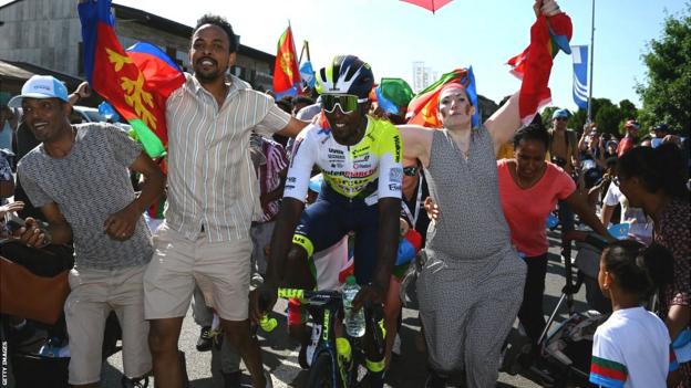 Biniam Girmay celebrates his signifier    triumph   astatine  the Tour de Suisse with chap  Eritreans