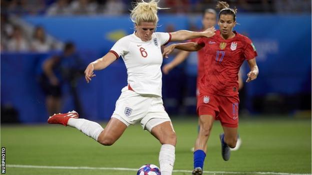 Millie Bright about to kick a ball