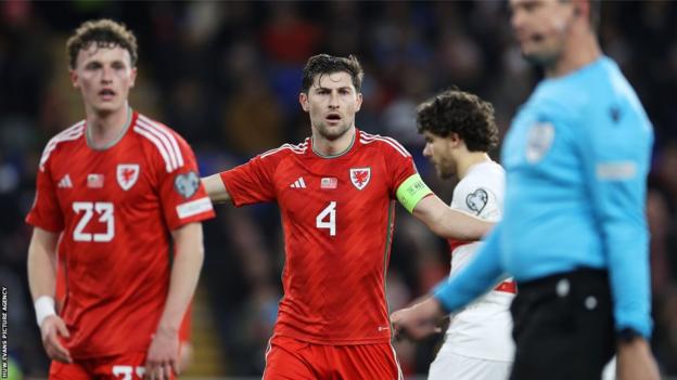 Wales captain Ben Davies shows his disbelief after Turkey are awarded their equalizing penalty
