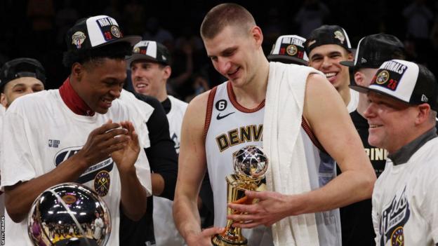 Nikola Jokic celebrates with his teammates as he receives the MVP award after the Denver Nuggets win the NBA Western Conference Finals in 2023
