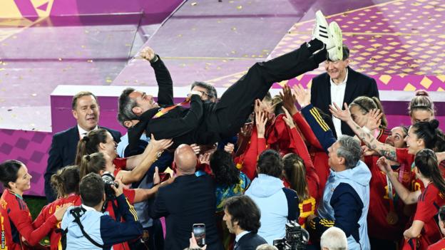 Spain boss Jorge Vilda is lifted up by some of his players after they were crowned world champions