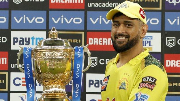 CSK captain MS Dhoni smiles as he holds up the 2021 IPL trophy