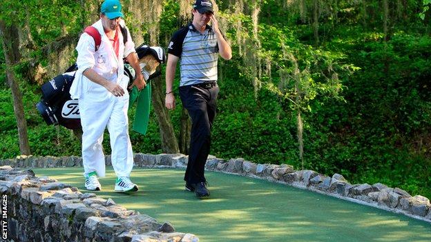 Rory McIlroy walking over the Nelson Bridge on the 13th hole with his caddie during the final round of the 2011 Masters