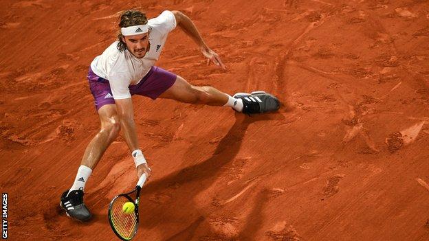 Stefanos Tsitsipas stretches for a return against Daniil Medvedev in their French Open quarter-final