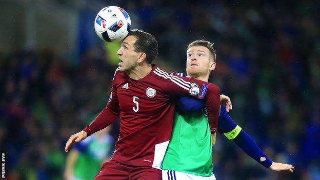 Latvia's Ojeg Laizans contends for possession with NI captain Steven Davis
