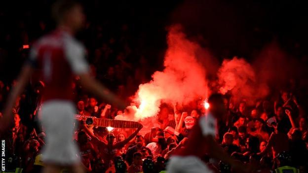 Cologne fans lit flares during the Europa League group game at Arsenal