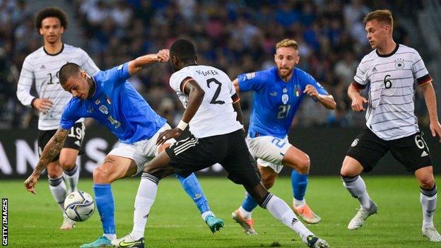 Italy's forward Gianluca Scamacca (left) challenges Germany's defender Antonio Rudiger