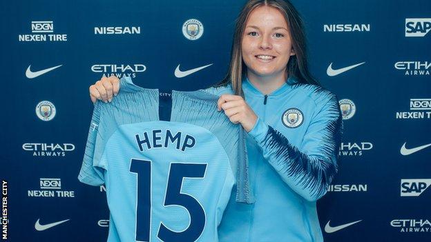 Lauren Hemp holds up a Manchester City shirt after her unveiling