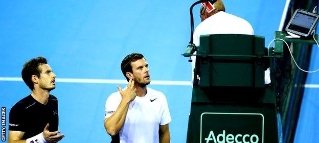 Great Britain team captain, Leon Smith and Andy Murray of Great Britain speak with chair umpire Pascal Maria