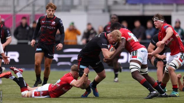 Nathan Michelow of Saracens is tackled with the ball