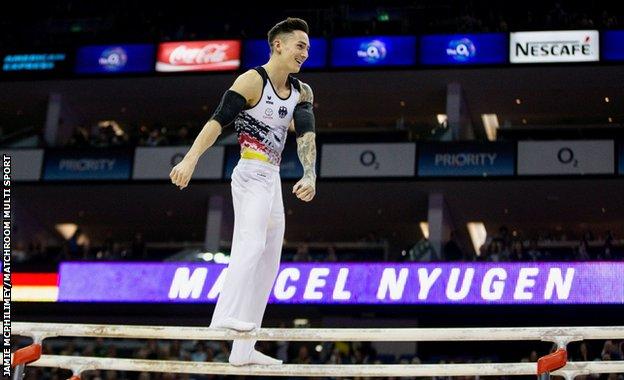 Marcel Nyugen flosses on the parallel bars at Superstars of Gymnastics