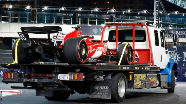 The car of Carlos Sainz of Spain and Ferrari is removed from the circuit on a truck after stopping on track