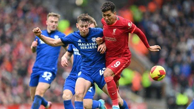 Cardiff City's Oliver Denham challenges Liverpool's Brazilian midfielder Roberto Firmino