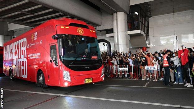 Manchester United fans greet the team bus at Bangkok airport