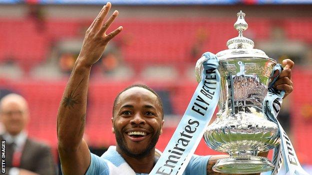 Manchester City's Raheem Sterling lifts the FA Cup