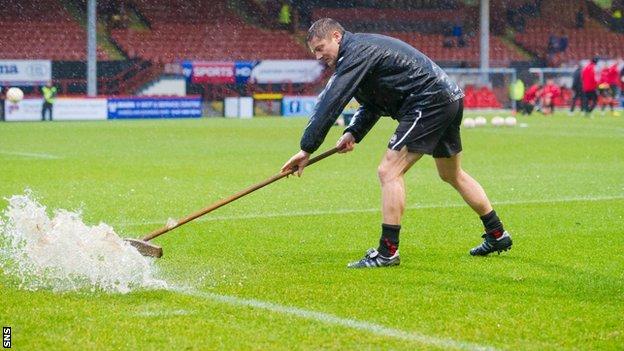 Groundsman at Firhill mops up surface water