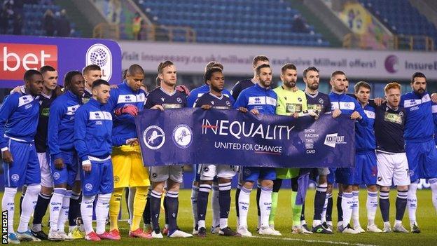 Millwall and QPR players holding an anti-racism banner before their game on 8 December 2020