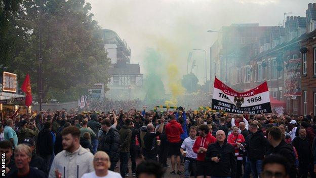Manchester United fans march to Old Trafford in protest of the club's ownership